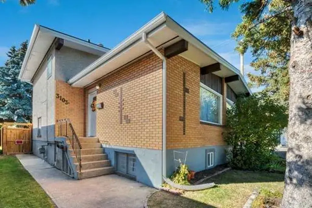 The brick front of 3103A 38 Street SW, with steps up to the front door