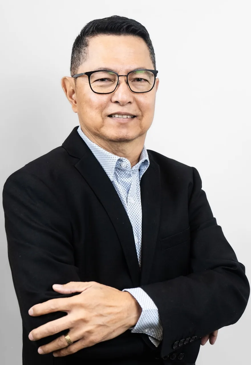 Rene Asprer in a dark blazer, arms folded